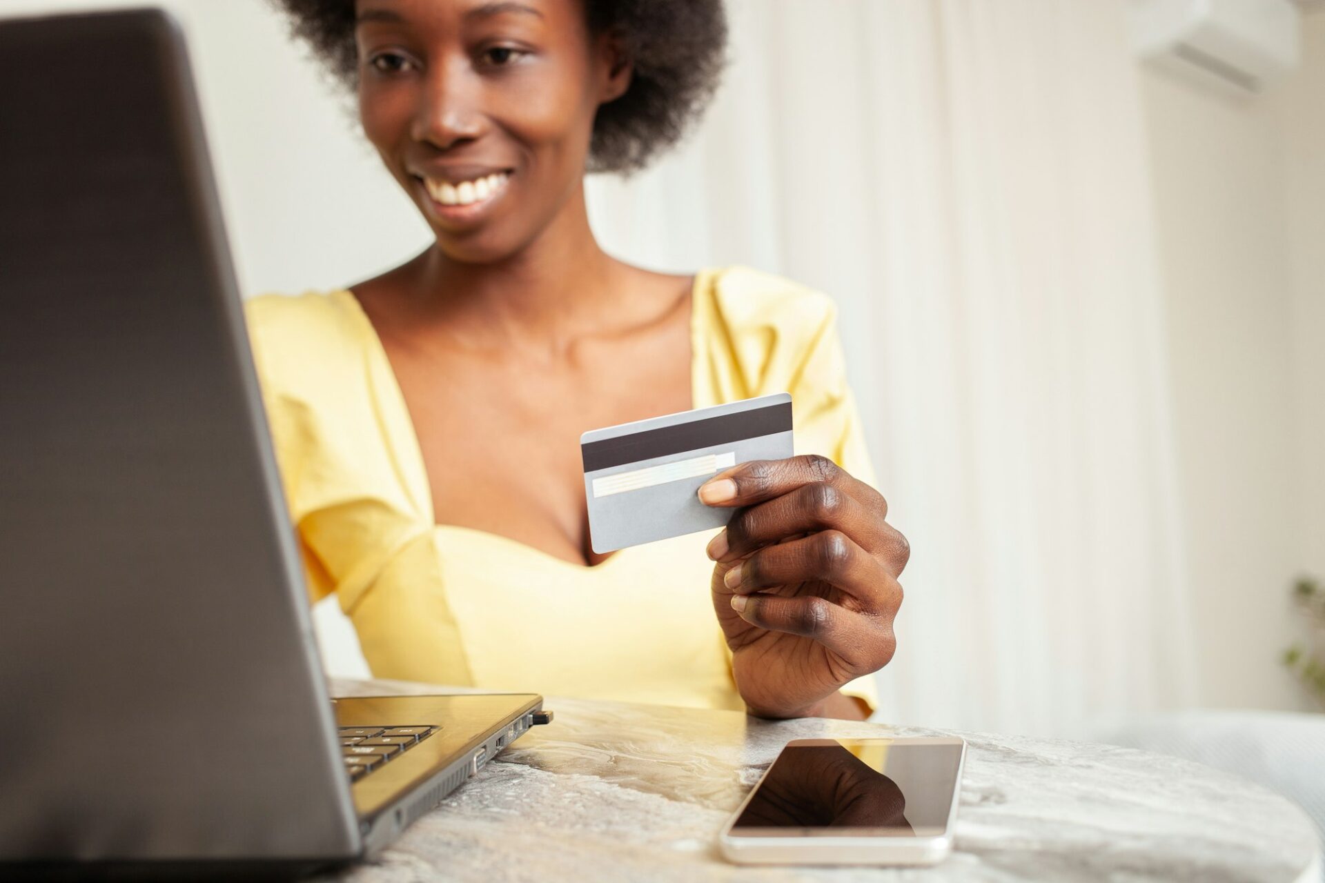 beautiful African American black woman uses a bank card to Shopping online. Delivery of goods to